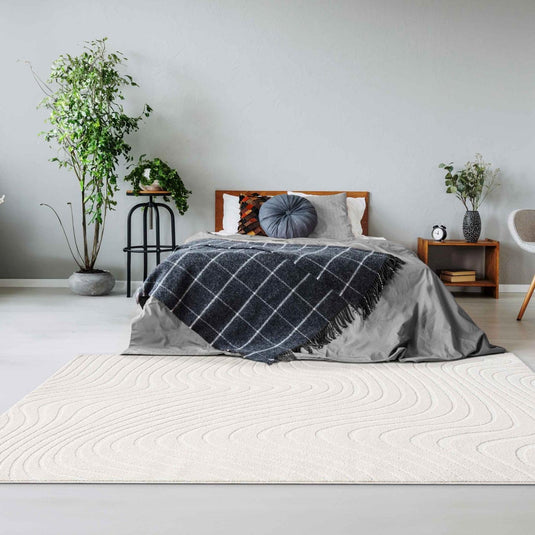 cream_geometric_area_rug_used_in_a_bedroom