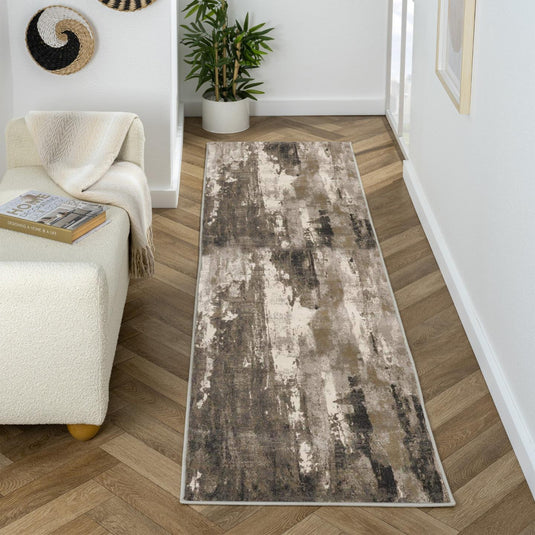 Long rectangular beige runner rug on a wooden floor with a white wall and plant in the background