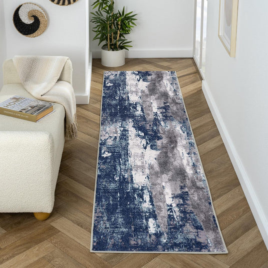Long rectangular blue and gray patterned rug on a wooden floor in a living room setting.