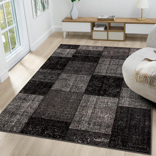 Living room with a checkered black and gray rug, white sofa, and wooden coffee table.
